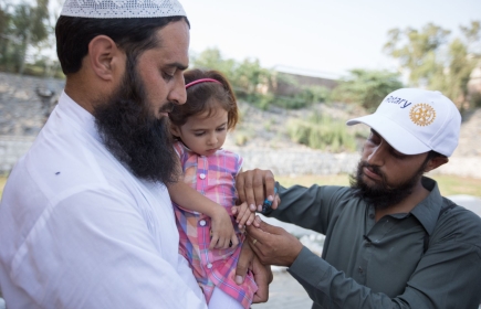 Ein Impfhelfer markiert in Pakistan den Finger eines geimpften Kindes. (Foto: RI)